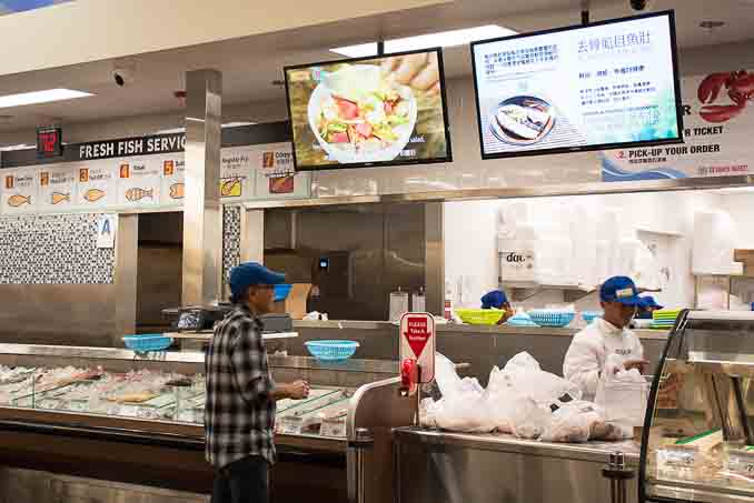 99大华超市在圣地亚哥南郡Chula Vista的新店4月1日正式开张，成为大圣地亚哥地区的第三家99大华超市。图为该超市的鱼类区，提供免费处理以及蒸、炸鱼服务，还有电视屏幕显示中国菜做法演示。（摄影：杨婕）